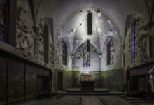 Verlassene Kirche mit Graffiti und bröckelndem Putz.