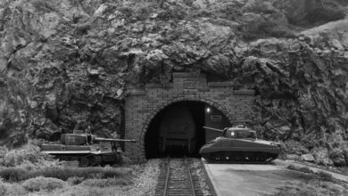 Diorama: Tiger- und Sherman-Panzer vor Gebirgstunnel mit Gleisen.